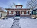 Brick home with front porch and steps, winter scene at 1307 W Congress Ave, Indianapolis, IN 46208