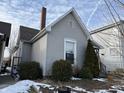 Side view of a gray house with landscaping and a chimney at 1402 Olive St, Indianapolis, IN 46203