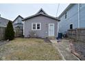 Gray single Gathering home featuring a side yard, a small garden, and a side entrance with a storm door at 1719 Fletcher Ave, Indianapolis, IN 46203