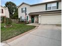 Two-story house with a green door, landscaping, and a two-car garage at 1830 Sweet Blossom Ln, Indianapolis, IN 46229