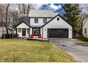 Charming two-story home boasts a well-manicured lawn, black trim, and attached two car garage at 333 S 4Th St, Zionsville, IN 46077