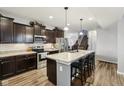 Modern kitchen features dark wood cabinets, stainless steel appliances, and a large center island with bar seating at 373 Brianne Ln, Danville, IN 46122