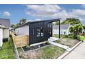 Stylish house with gray and black siding, a wooden fence, and landscaping at 459 N Concord St, Indianapolis, IN 46222