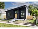Contemporary home with black siding, a wood door, and small front yard at 459 N Concord St, Indianapolis, IN 46222