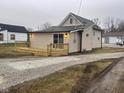 Tan house with a wooden deck and gravel driveway at 633 S 17Th St, Elwood, IN 46036