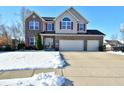 Two-story brick home with a two-car garage and snow-covered landscaping at 861 Stardust Ct, Franklin, IN 46131