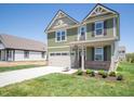 Well-maintained two-story home with a two-car garage and a neatly landscaped front yard at 8703 Duncan St, Fortville, IN 46040
