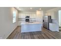 Bright, open kitchen with white cabinets, stainless steel appliances, and a center island at 8703 Duncan St, Fortville, IN 46040