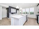 Modern kitchen with white cabinets, island, and stainless steel appliances at 10936 Hanovarian St, Zionsville, IN 46077