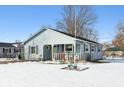 Blue house exterior with snow covered yard and visible neighbors at 1650 Stout St, Martinsville, IN 46151