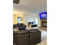 Cozy living room with a brick fireplace and comfortable black leather seating, perfect for relaxing and watching TV at 2322 Bainbridge Rd, Greenwood, IN 46143