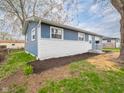 Charming blue and white home featuring fresh landscaping, healthy green lawn and mature trees at 2814 S Randolph St, Indianapolis, IN 46203
