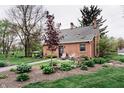 Charming red brick home with cozy outdoor seating, and inviting landscaping, framed by a lush green lawn at 301 Lowry St, Jamestown, IN 46147