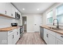 Modern kitchen with white shaker cabinets, butcher block countertops, and stainless steel appliances at 317 N Belleview Pl, Indianapolis, IN 46222