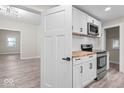 Renovated kitchen boasting white cabinets, butcher block counters, and stainless steel appliances at 317 N Belleview Pl, Indianapolis, IN 46222