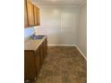 Galley kitchen with wood cabinets, double sink, and tiled floor at 5778 E 30Th St, Indianapolis, IN 46218
