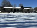 Stone house with snow-covered lawn and winter trees at 7812 S 400 W, Columbus, IN 47201