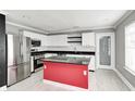Modern kitchen with white cabinets, red island, and granite countertops at 10069 Boysenberry Dr, Fishers, IN 46038