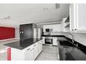 Modern kitchen with white cabinets, red island, and granite countertops at 10069 Boysenberry Dr, Fishers, IN 46038