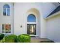 Elegant front entrance featuring a striking arched window above double doors and manicured greenery at 1535 Cricklewood Way, Zionsville, IN 46077