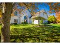 Charming white home framed by colorful autumn leaves creates a picturesque scene of suburban living at 1535 Cricklewood Way, Zionsville, IN 46077