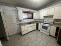 White kitchen cabinets, vinyl flooring, and a view of the back door at 1623 Sherwood Dr, Anderson, IN 46012