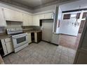 Galley kitchen with white cabinets and vinyl flooring at 1623 Sherwood Dr, Anderson, IN 46012