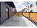 Modern backyard with wood fence, concrete patio, and small grass area, offering a blend of privacy and low-maintenance design at 1674 Solebar Way, Westfield, IN 46074