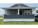 Inviting home exterior featuring a covered porch with a brick facade and gray siding at 18 S Franklin St, Greenfield, IN 46140