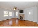 Cozy living room with hardwood floors, a ceiling fan, and a decorative tile fireplace at 1901 E 68Th St, Indianapolis, IN 46220
