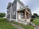 Side view of a duplex with stylish gray siding and a welcoming covered porch at 2033 Carrollton Ave, Indianapolis, IN 46202