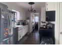 Galley kitchen with stainless steel appliances, white cabinets, and hardwood floors at 409 E Ulen Dr, Lebanon, IN 46052