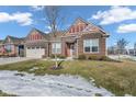 Two-story brick home with a front yard and mature tree at 5246 Parkhurst Xing, McCordsville, IN 46055