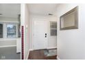 Bright entryway with a white front door, hardwood floors, and a decorative mirror at 8198 Wade Hill Ct, Indianapolis, IN 46256