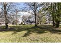 House nestled amongst mature trees in a spacious front yard at 8365 N Pennsylvania St, Indianapolis, IN 46240