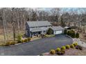 Aerial view of gray home with a long driveway and nice landscaping and small pond in the background at 8850 W State Road 46, Columbus, IN 47201