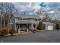 Charming two-story home boasts a well-manicured lawn, attached garage, and welcoming front porch at 8850 W State Road 46, Columbus, IN 47201