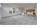 Spacious living room with grey carpet and kitchen view at 1011 Grassy Branch Dr, Indianapolis, IN 46239