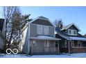 Two-story gray house with a front porch, and snow covered lawn at 1053 W 35Th St, Indianapolis, IN 46208