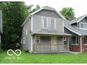 Two-story home featuring a covered front porch, and gray siding at 1053 W 35Th St, Indianapolis, IN 46208