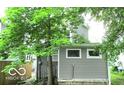 The back of the home, with a gray exterior and surrounded by greenery at 1053 W 35Th St, Indianapolis, IN 46208