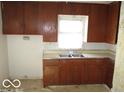 Small kitchen with dark brown cabinets and double sink at 1053 W 35Th St, Indianapolis, IN 46208