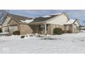 Brick ranch home with attached garage, snowy yard, and neighborhood view at 121 W Wind Chime Cir, Greenwood, IN 46143