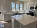 Modern kitchen with white cabinets, large island, and stainless steel appliances at 14569 Hanford Ln, Carmel, IN 46032