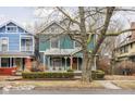 Charming two-story home with teal siding and inviting front porch, framed by a mature tree at 1468 Alabama St, Indianapolis, IN 46202