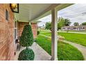 Front porch with brick columns and artificial topiaries at 4657 E 62Nd St, Indianapolis, IN 46220
