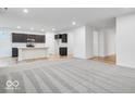 Open-concept living space with modern gray carpet and dark cabinets for a sleek and inviting atmosphere at 1020 Stonehaven Dr, Indianapolis, IN 46239