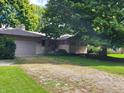 Brick ranch home with a gravel driveway and lush lawn at 1165 Wood Ct, Indianapolis, IN 46227