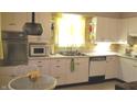 Retro white kitchen with stainless steel appliances and yellow walls at 1165 Wood Ct, Indianapolis, IN 46227