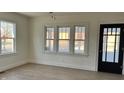 Bright living room with hardwood floors, large windows, and a black door at 1421 S Burlington Dr, Muncie, IN 47302